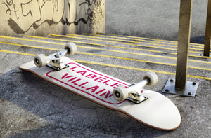 Labeled Villain skateboard at skate park.